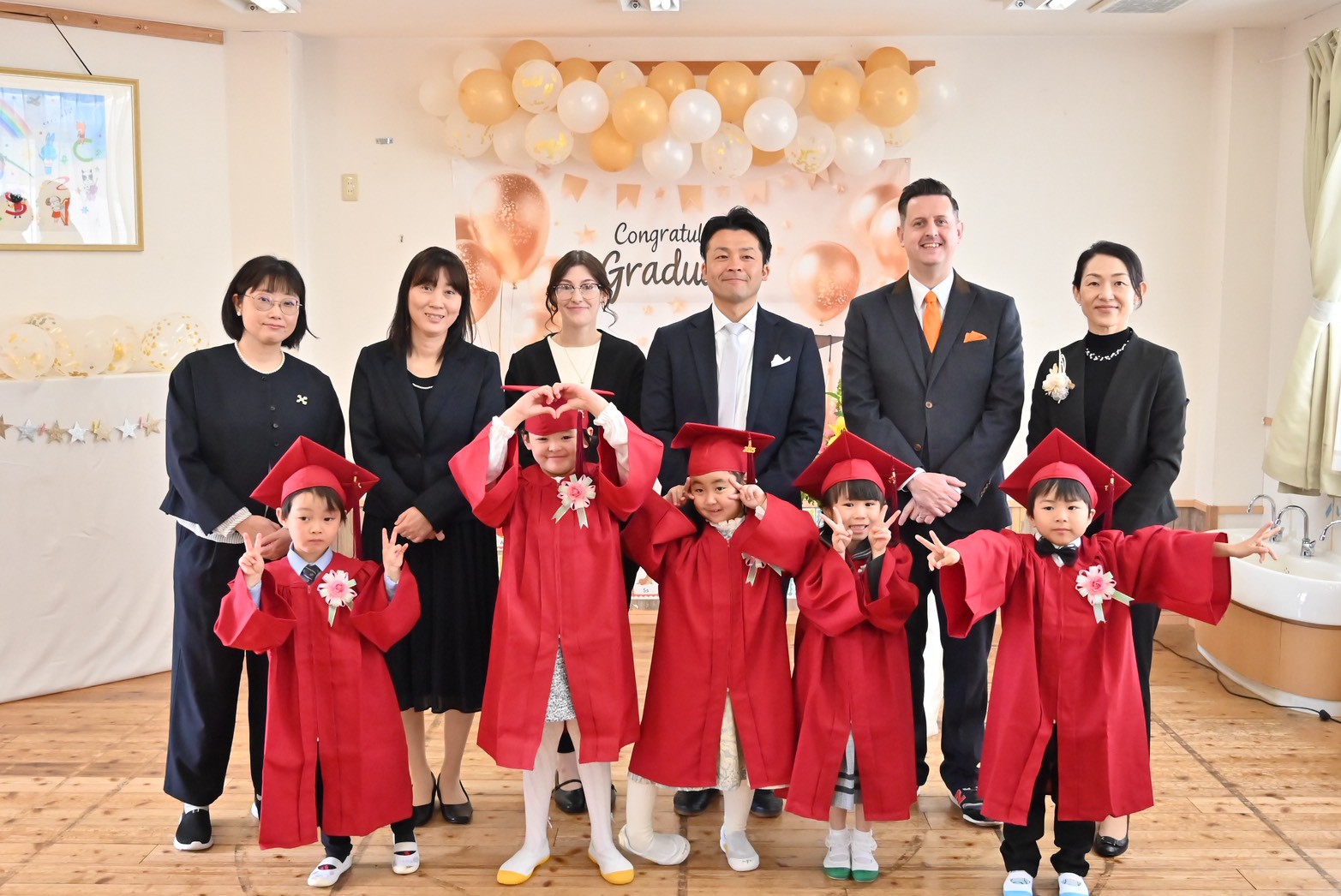 卒園式での園児と先生たちの集合写真